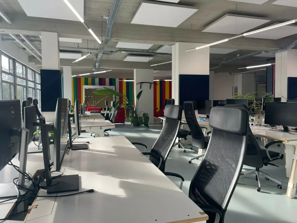 Moderne en ruime kantoortuin aan de Van Leijenberghlaan met werkplekken, ergonomische stoelen en kleurrijke wandpanelen.